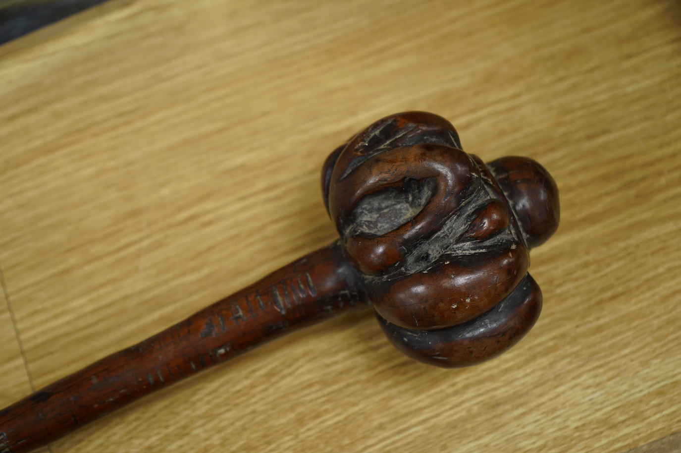 A 19th century Fiji carved hardwood throwing club, Ula, 40cm long, swollen head divided into nine segments, the handle carved with zigzag decoration and incised lines. Condition - good.